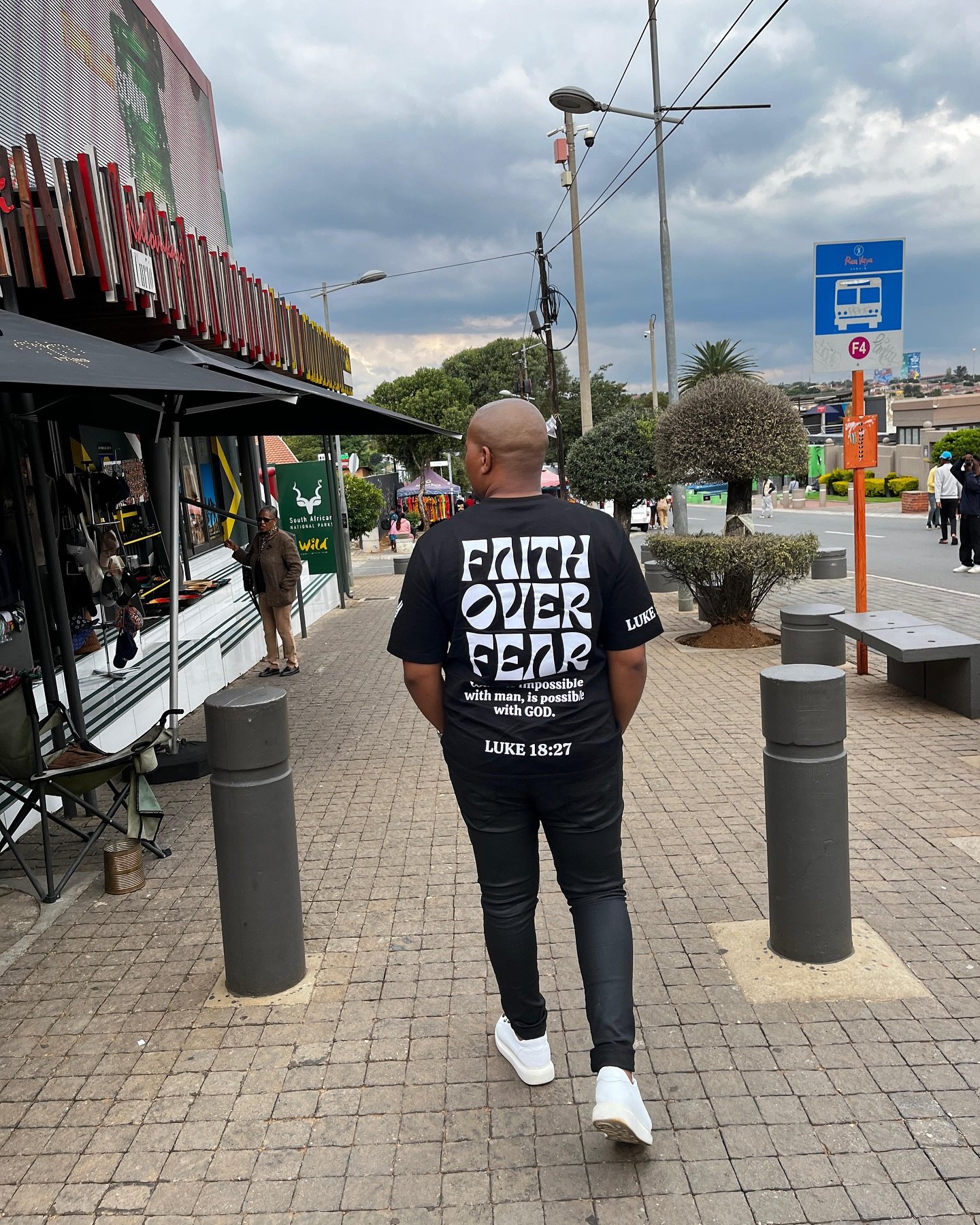 Man wearing Faith Over Fear tee walking with purpose