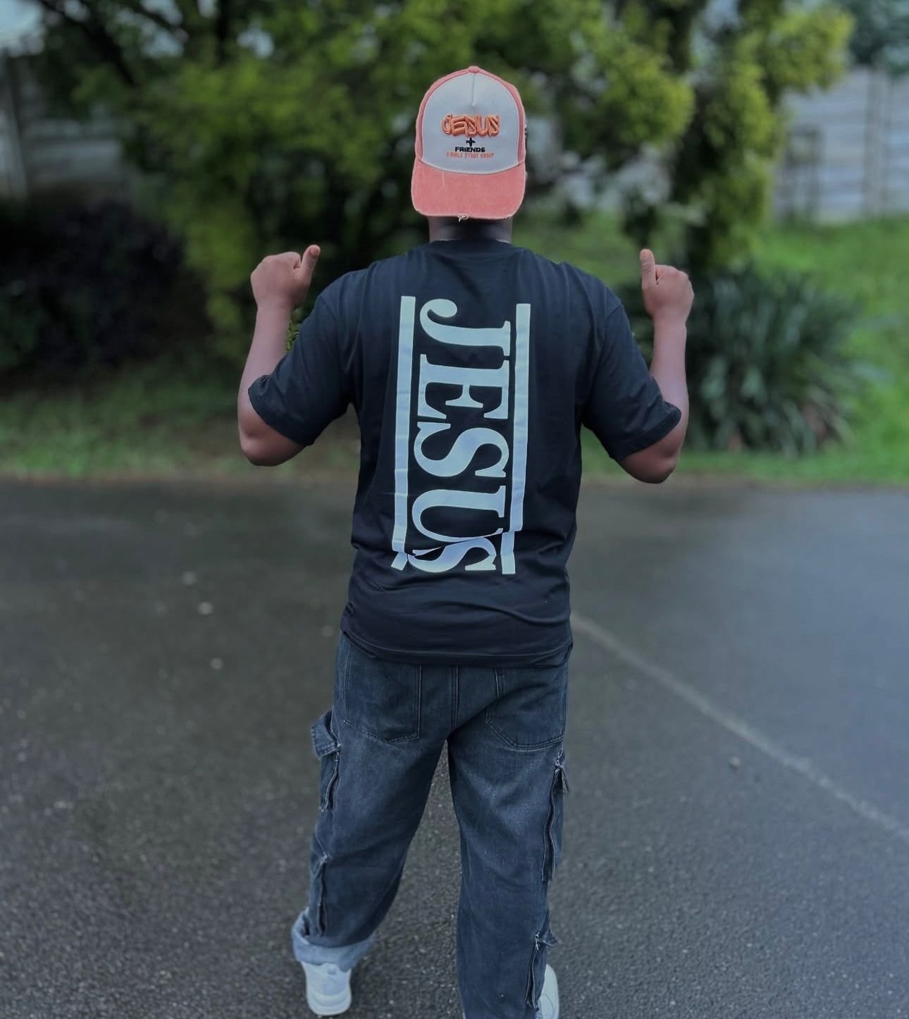 JESUS tee in black — bold white print, walking forward